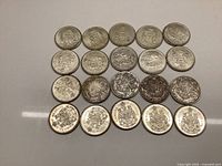 Twenty Canadian 50 cent coins arranged in four rows on a flat surface.