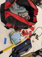 Red and black Aero-Dynamic duffel bag open showing braided rope and folded flags