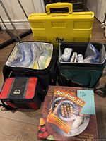 Overview of picnic set with coolers, storage containers, ice packs, and yellow carrying case.