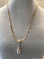 Full length view of the gold tone curb chain necklace on a mannequin showing the overall look and length.