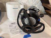 Shark Professional Portable Steam Cleaner with attached hose and handle, Honeywell humidifier, and Shark instruction manual visible on white surface.