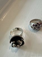 Two vintage silver rings placed on a white surface to show design details.