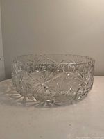 Side view of a clear cut crystal bowl showing starburst and geometric cut designs around the body.