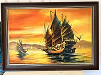 Frontal view of the large oil painting showing sailing ships at sunset with rich colors and details in a wooden frame.