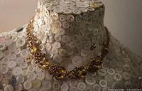 Front view of necklace showing rhinestone floral clusters and gold-tone metal.