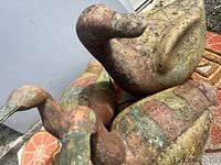 Four terracotta bird sculptures arranged on patterned rugs, showing worn paint and detailing.