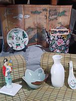 Overview of entire lot including screen, plate, teapot, placemats, figurine, bowl, spoon