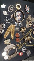Assortment of costume jewelry laid out on black background