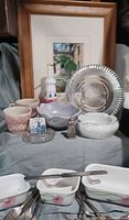 Group shot shows framed art, dishware, bakeware, flatware