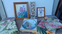Overall lot showing tablecloths, collectors plate, framed prints and tile