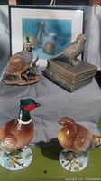 Overall lot view showing framed art and all four bird figurines