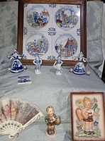 Group shot showing all items: Hummel plaque, Hummel figurine, four Delft figurines, Delft clog, framed Delft tiles and fan