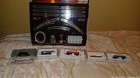 Starter set box with track sections, controller, wiring and five rolling stock cases displayed