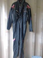 Full view of black Spyder coveralls hanging to show overall style and length