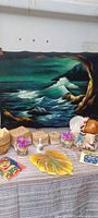 Overview showing velvet seascape painting and assorted decor on table