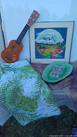 Group shot of quilt, framed art, ukulele, leaf plate, and cocktail umbrellas