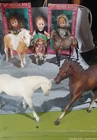 Group shot of two boxed Vogue dolls, loose doll, small figurine, and four Breyer horses