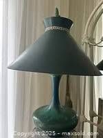 Photo showing the antique green porcelain lamp with matching lampshade, highlighting its shape, color depth, and decorative ring detail on the shade.