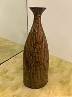 Photo of tall decorative vase with copper mosaic pattern, showing narrow neck and wide body.