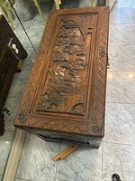 Top angled view showing intricate carved relief and bordering pattern on chest lid.