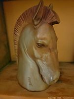 Front and side view of the porcelain horse head sculpture showing detailed craftsmanship and glaze finish.