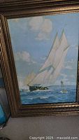 Framed original oil painting of a sailboat at sea with blue sky and clouds, showing textured brush strokes and detailed sails.