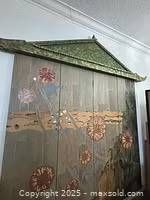 Frontal view of the full wooden pagoda wall screen with floral painted panels and pagoda top