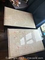 Overhead view of two rectangular cream and ochre marble topped bedside tables placed side by side.