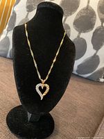 Necklace displayed on black velvet bust showing pendant and chain drape