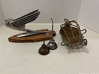 Front view of hood ornament, two oilers and light cage arranged on white background