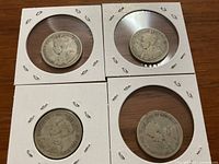 Obverse sides of four Canadian silver quarters from 1933 to 1936 in protective holders