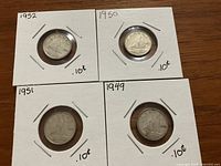 Reverse sides of 1949, 1950, 1951, 1952 Canadian silver dimes showing the sailing ship design and year.