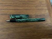 Green marbled Waterman Skywriter fountain pen uncapped showing nib and pen body.