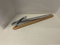 Front angle view showing the chrome stylized bird hood ornament mounted on a metal and wood detailed base.