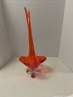 Full view of the orange glass bowl showing tall twin peaks and rounded base