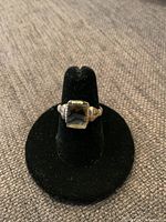 Front view of ring on black display, showing moss agate and bezel