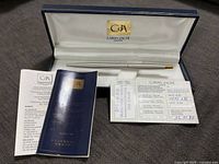 Caran d'Ache pen in opened official case alongside registration certificate and information booklet.