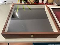 Top view of larger display cabinet with glass lid closed showing wooden frame and black interior