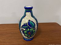 Front and side view of the ceramic vase showing colorful floral design and crackled glaze