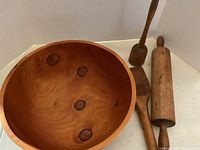 Image showing the exterior and interior of the hand turned Eastern Larch wooden bowl and parts of the utensils around it.