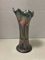 Front view of Fenton carnival glass vase showing rib and diamond pattern vertically along the body and ruffled top edge.