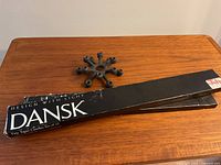 Box of Dansk Tapet candles and the vintage Jens Quistgaard designed candle holder on a wooden surface