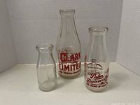Front view of three glass milk bottles