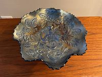 Top-down view of the carnival glass bowl showing detailed Peacock & Urn embossed pattern and scalloped edges.