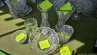 Image showing multiple crystal glassware pieces including vases, bowls, a candy dish, and catchall with visible cut patterns taken under natural light.
