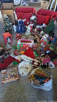 Full overview photo showing various Christmas decorations including mini trees, stockings, hats, figurines, garlands, and a puzzle box.