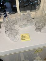 Full set of the cut crystal glassware including 4 flutes, 5 wine glasses, 7 water/tea glasses, a pitcher, a creamer, and a bowl arranged on a white surface.