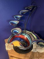 Front view of the colorful 6-level water fountain showing the largest bottom bowl with swirl colors and three smaller upper glass bowls.