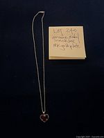 Full view of the necklace showing heart-shaped ruby pendant and gold plated chain.