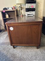 Side view of the wooden desk showing its side panel and legs.